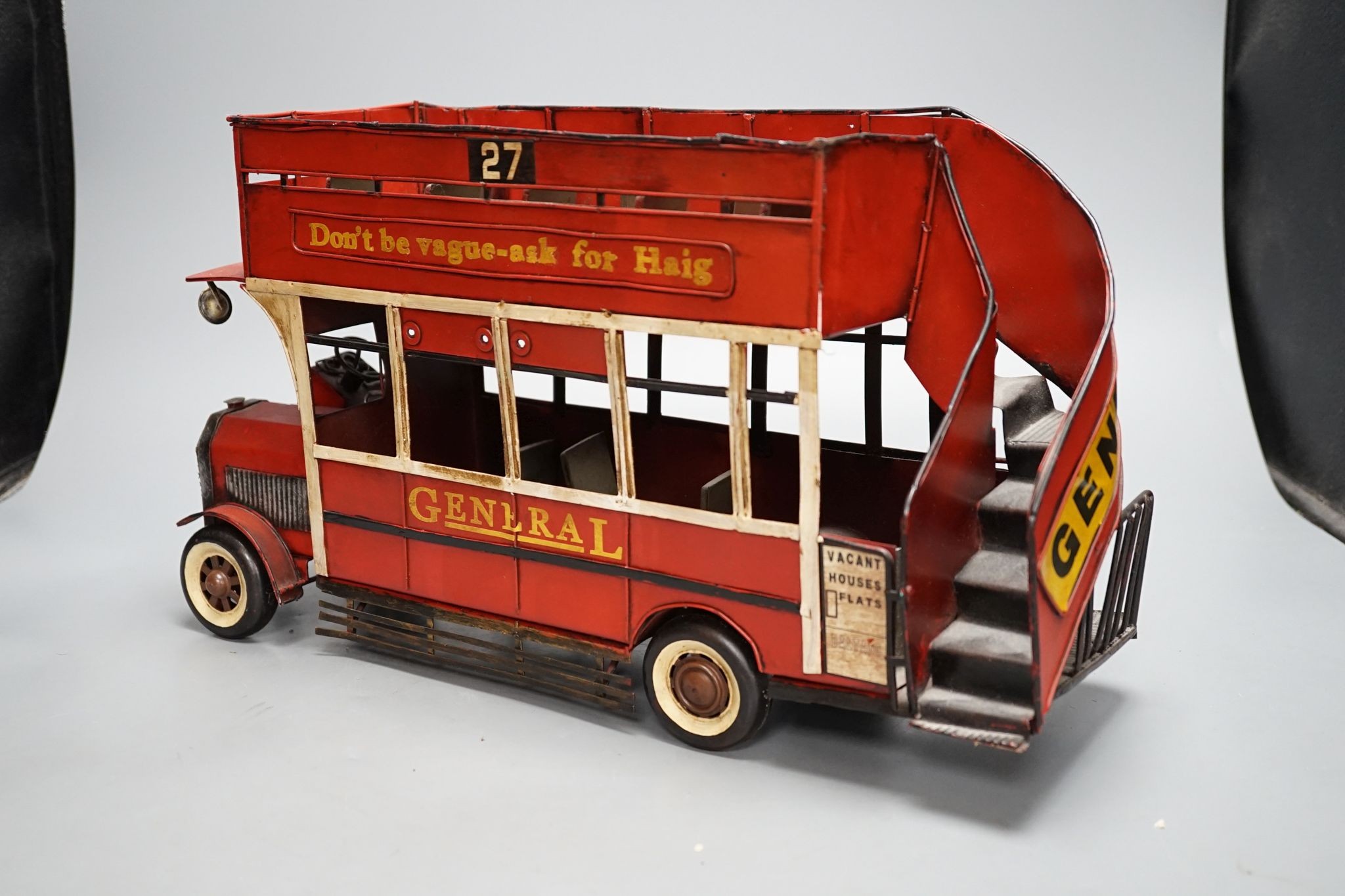 A reproduction tinplate double decker topless bus, the side reading ‘Don’t be vague - ask for Haig’, 42cm long